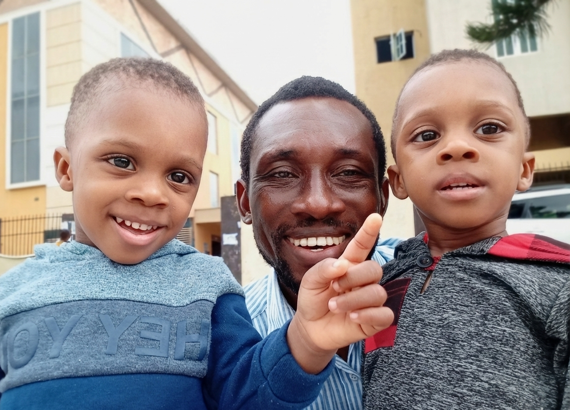 A Portrait of an African Man With His Twin Kids